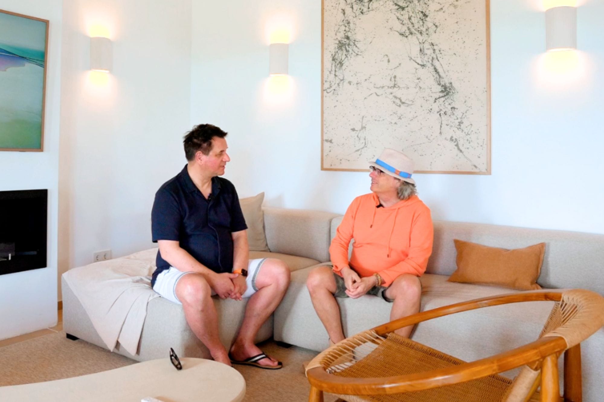 Zwei Männer sitzen auf der Couch in einer Villa auf Mallorca.