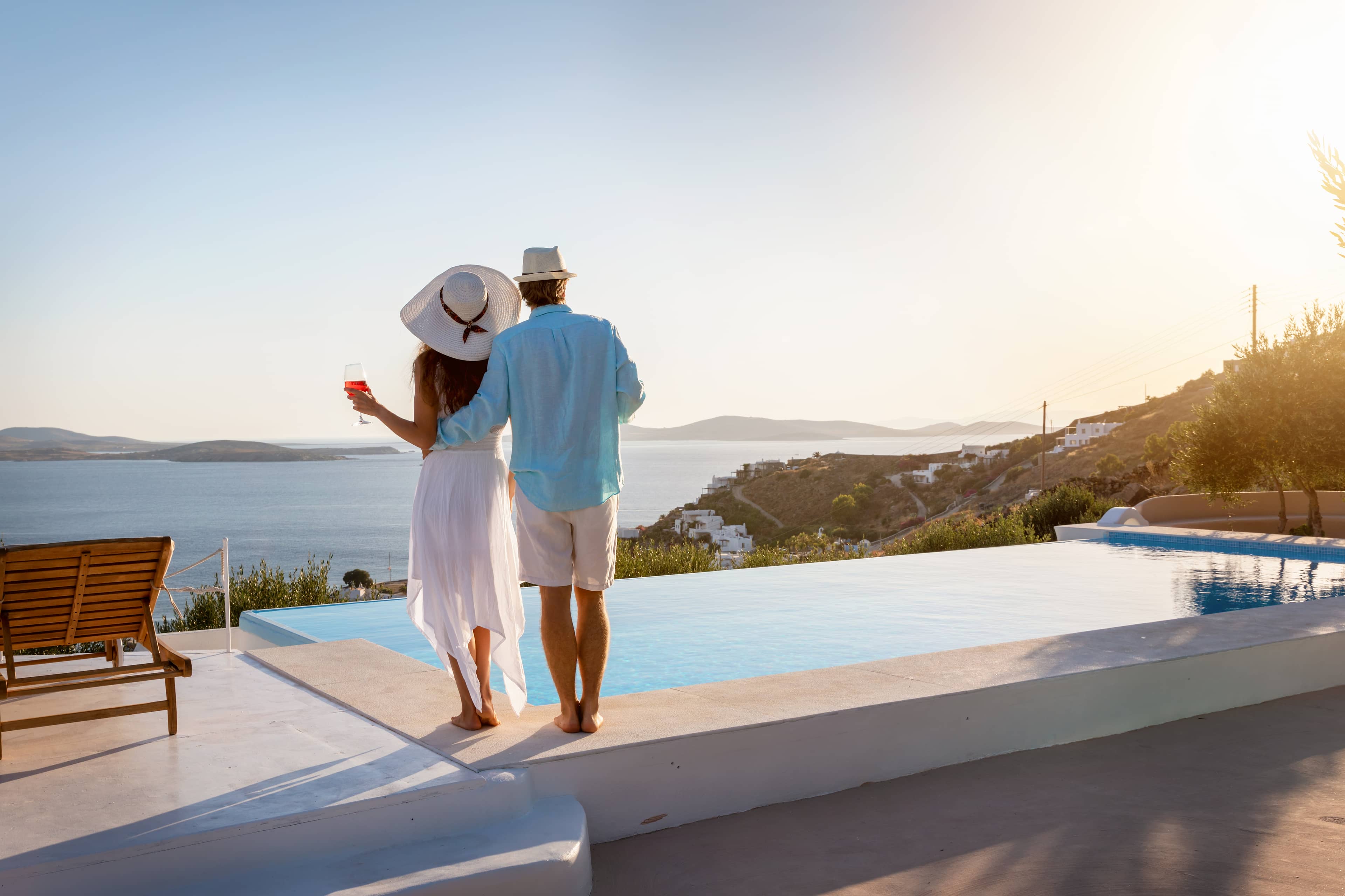 Couple by the pool looking at the sea view.